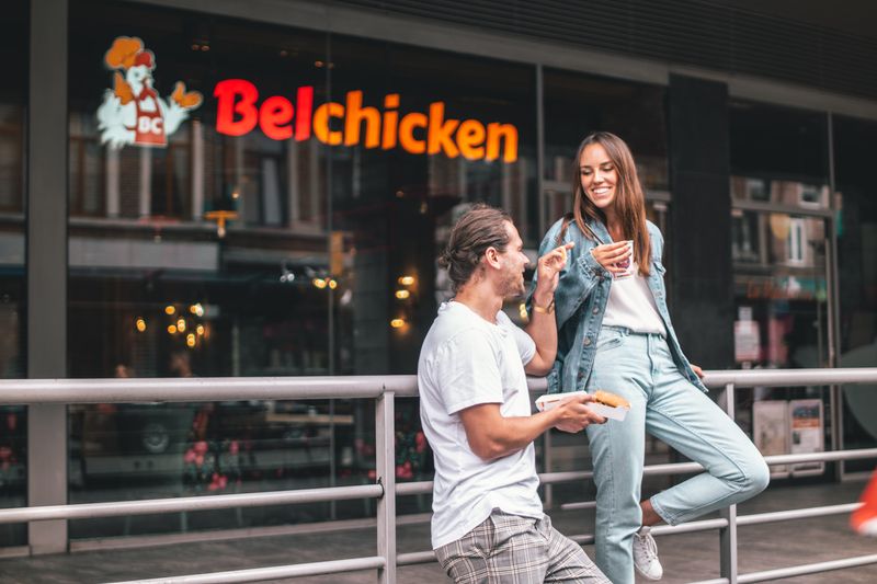 Friends talking in front of Belchicken restaurant 